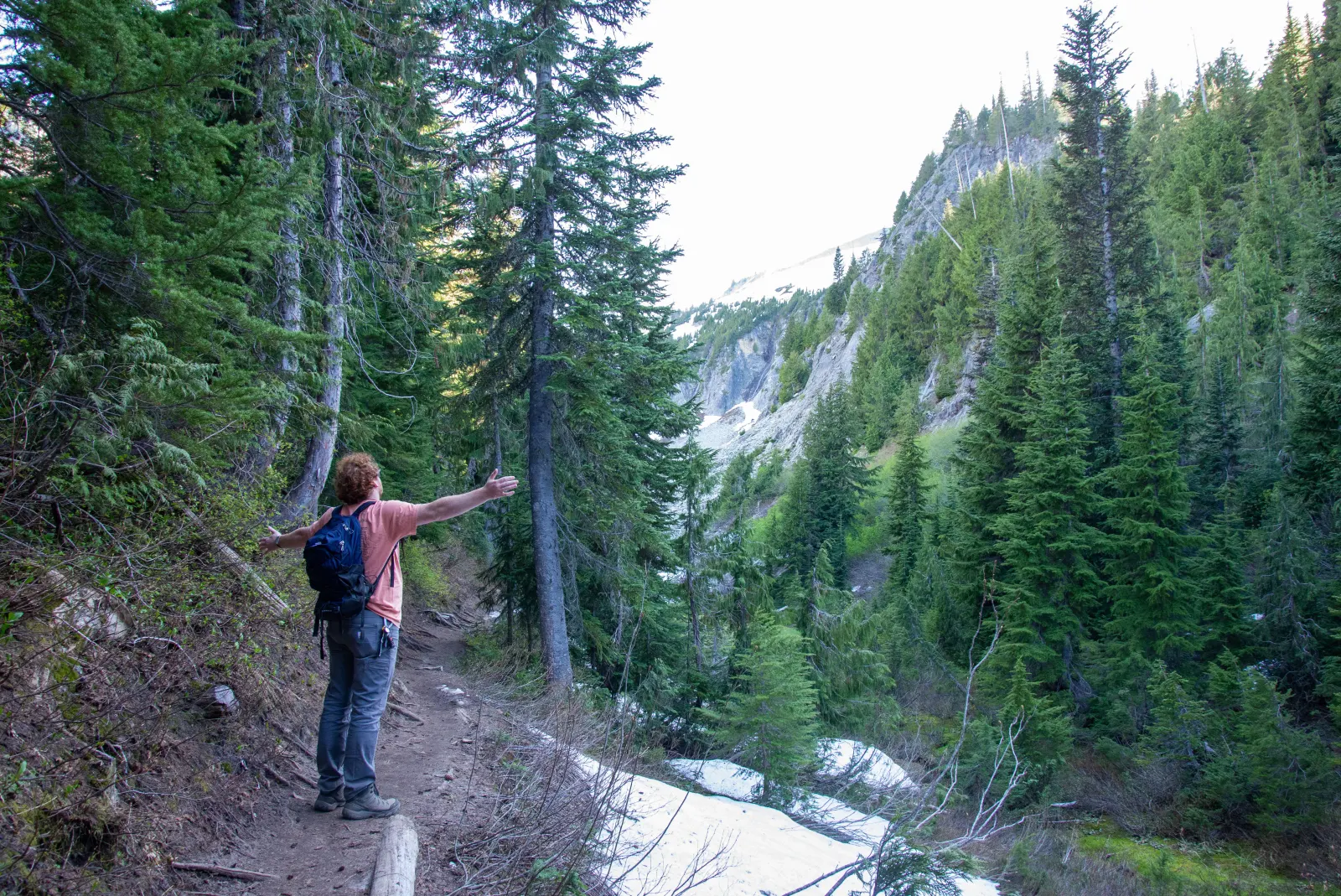 Mason standing on a mountain trail surrounded by trees